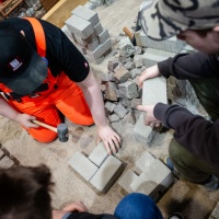 Ein Handwerker arbeitet mit Steinen an einer Grundfläche. Ein Handwerker arbeitet mit Steinen an einer Grundfläche.