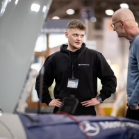 Ein Mann berät einen anderen Mann zu seinem Mercedes Benz Ein Mann berät einen anderen Mann zu seinem Mercedes Benz