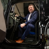 Ein Mann im Anzug sitzt in einem LKW Ein Mann im Anzug sitzt in einem LKW