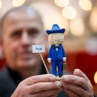 Ein Mann zeigt ein Miniatur Messemänchen in die Kamera. Ein Mann zeigt ein Miniatur Messemänchen in die Kamera.