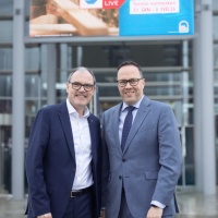 2 Männer in Anzügen stehen vor einem Banner der Handwerksmesse 2026. 2 Männer in Anzügen stehen vor einem Banner der Handwerksmesse 2026.
